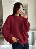 Person wearing a red sweater taking a mirror selfie indoors.