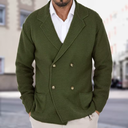 Man wearing a green double-breasted jacket with a blurred street background