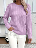Person wearing a purple cable knit sweater and white pants indoors.