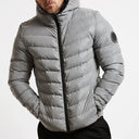 Gray puffer jacket worn by a person on a white background