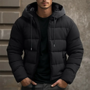 Person wearing a black puffer jacket against a neutral background
