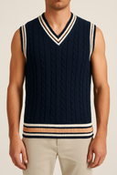 Navy blue knitted vest with striped details worn by a person on a neutral background