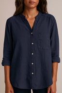 Navy blue button-up shirt worn by a person on a beige background