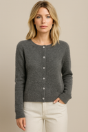 Woman wearing a gray cardigan against a beige background