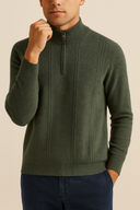 Man wearing a green sweater with a zipper on a beige background
