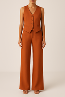 Brown vest and pants set on a plain background