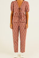 Person wearing a red patterned outfit set on a beige background