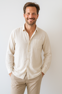 Man wearing a beige shirt and pants against a white background