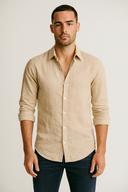 Man wearing a beige button-up shirt against a plain background