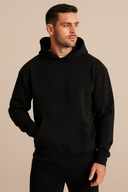 Man wearing a black hoodie against a beige background