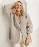 Woman wearing a beige cardigan against a white background