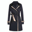 Navy blue trench coat with beige accents on a white background