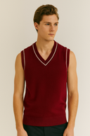 Man wearing a red sweater vest against a plain background