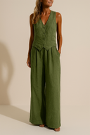 Woman wearing a green jumpsuit against a beige background