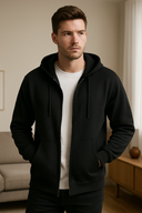 Man wearing a black hoodie and white shirt in a room with neutral decor