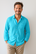 Man wearing a bright blue shirt and beige pants against a plain background