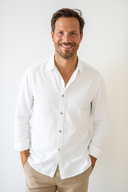 Man wearing a white shirt and beige pants against a plain background