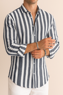 Man wearing a navy and white striped shirt against a beige background