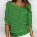 Green knitted sweater worn by a person on a white background
