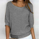 Person wearing a gray textured sweater on a white background