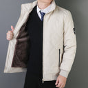Person wearing a beige quilted jacket with a gray background