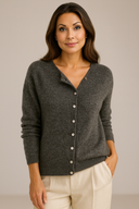 Woman wearing a gray cardigan against a beige background