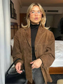 Person wearing a brown coat in an indoor setting
