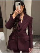 Person wearing a burgundy suit taking a mirror selfie.