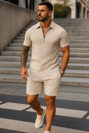 Man wearing a beige patterned outfit walking on steps outdoors