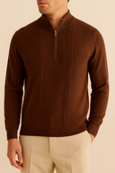 Man wearing a brown half-zip sweater against a beige background