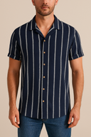 Man wearing a navy and white striped shirt with buttons on a beige background