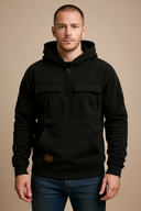 Man wearing a black hoodie with front pockets on a beige background