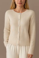 Woman wearing a beige cardigan against a neutral background