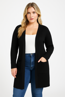 Woman wearing a black cardigan over a white top and blue jeans on a white background