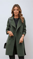 Woman wearing a green coat against a light background