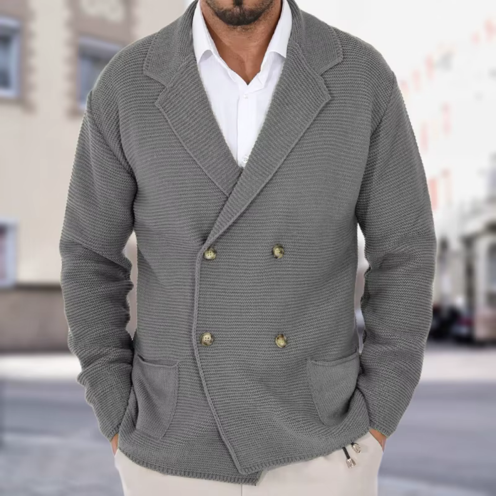 Man wearing a gray knitted blazer with a blurred city street background