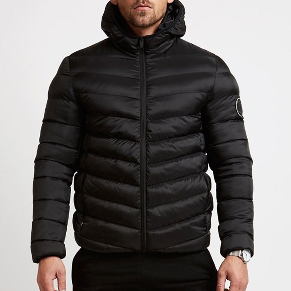 Black puffer jacket worn by a person on a light gray background