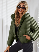 Woman wearing a green puffer jacket against a white background
