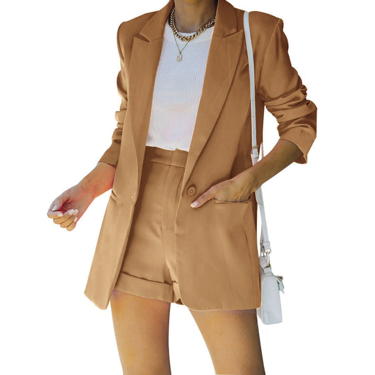 Person wearing a beige suit with a white top and carrying a white handbag on a white background