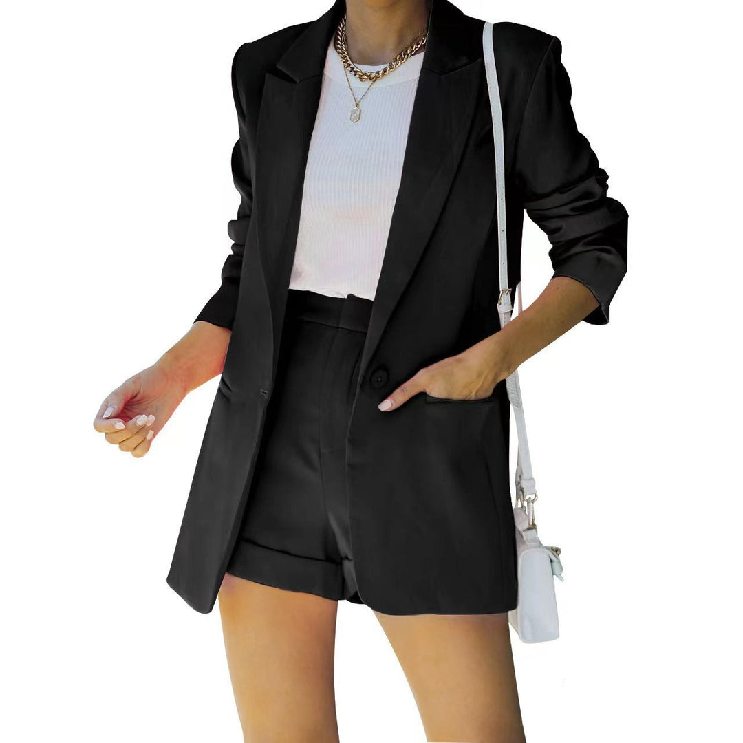 Person wearing a black blazer and shorts with a white top on a white background