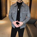 Person wearing a checkered jacket over a black shirt in an indoor setting