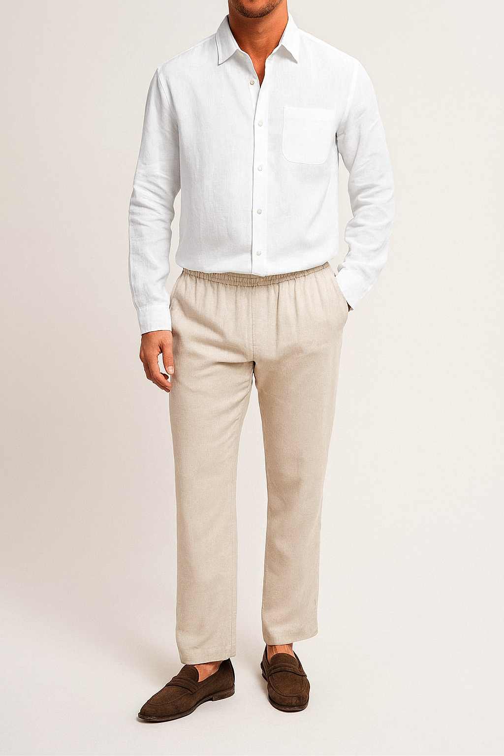 Person wearing A longsleeve men's linen set, consisting of a white shirt and beige pants, displayed on  plain background