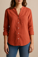 Person wearing a red shirt with rolled-up sleeves against a beige background