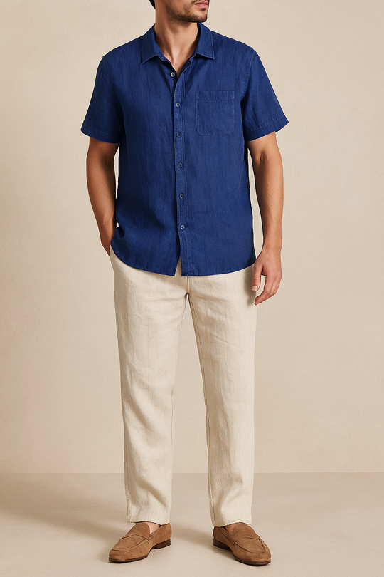 Man wearing a blue shirt and beige pants on a beige background