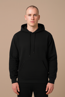 Man wearing a black hoodie on a beige background