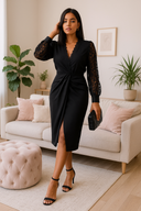 Woman in a black dress standing in a living room with a couch and plants.