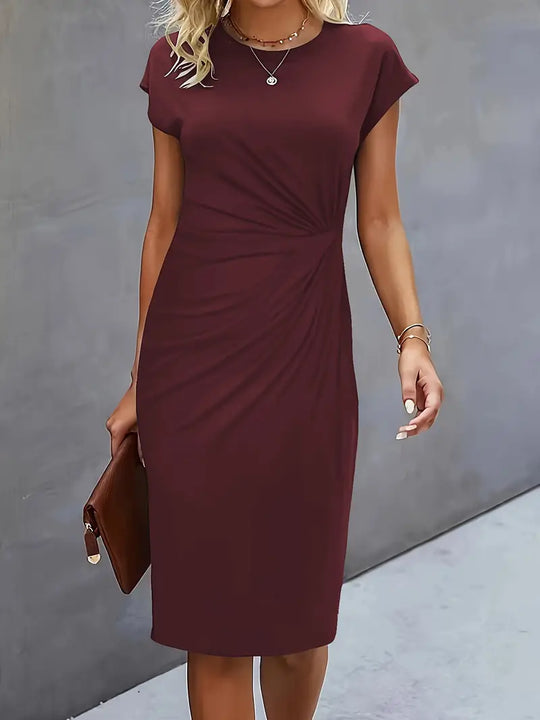 Woman wearing a burgundy dress against a gray background
