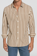 Man wearing a brown and beige striped shirt with rolled-up sleeves on a plain background