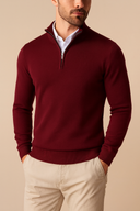 Man wearing a burgundy half-zip sweater with beige pants on a beige background