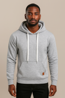Man wearing a gray hoodie with a brand logo on a beige background